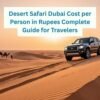 Desert Safari Dubai Cost per Person in Rupees – SUV on golden sand dunes with camels and travelers enjoying the desert sunset.