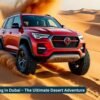 Dune Bashing in Dubai with a red SUV racing across golden desert dunes under a bright sky.