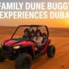 Family enjoying a dune buggy ride in Dubai desert at sunset.