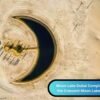 Aerial view of the crescent shaped Moon Lake in Dubai’s Al Qudra Desert, surrounded by sand dunes with a few palm trees and vehicles nearby.
