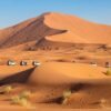 Dubai-desert-safari-overview-showing-Lahbab-and-Al-Marmoom-deserts-red-dunes-and-golden-sand-4x4-vehicles-in-distance-Dubai-UAE