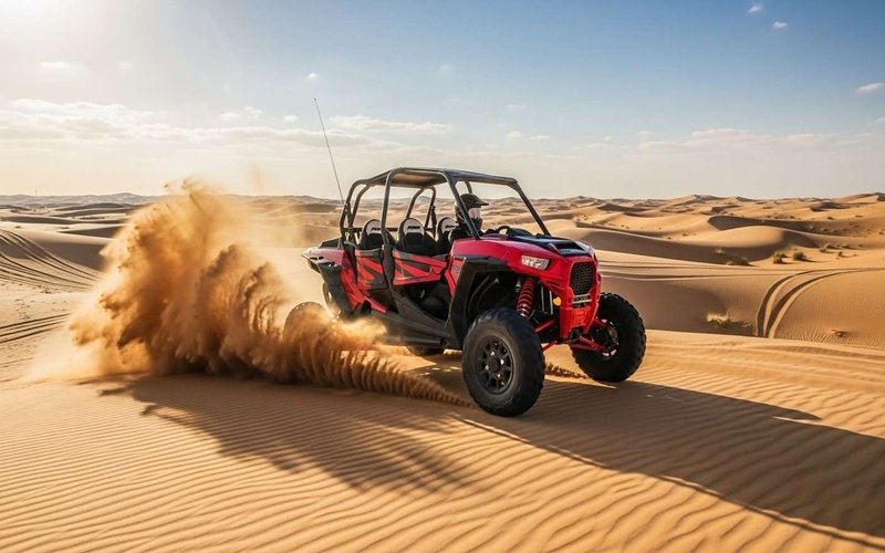 Red-2-seater-Polaris-dune-buggy-driving-over-golden-Dubai-desert-dunes-under-clear-blue-sky-adventurous-self-drive-desert-ride.